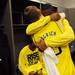 Michigan senior Matt Vogrich hugs fifth-year senior Corey Person in the locker room after the Wolverines beat the Kansas Jayhawk in overtime to advance to the Elite Eight at Cowboys Stadium in Arlington, Texas on March 29, 2013. Melanie Maxwell I AnnArbor.com